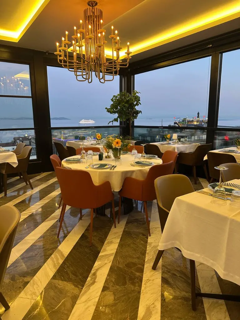 Gün batımında salon, deniz manzarası ve sofra düzeni